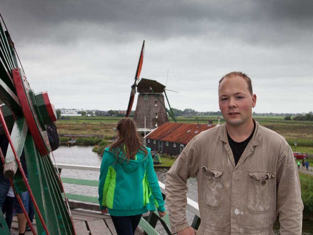 A young miller standing on a Dutch Windmill